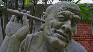 Statue of Fellow Scratching His Ear With a Stick
